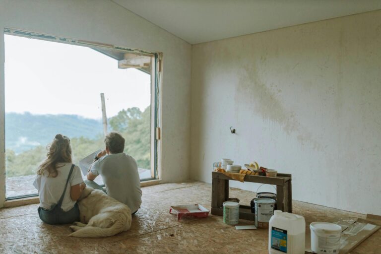 Backview of Couple sitting together in their semi finished remodeled home