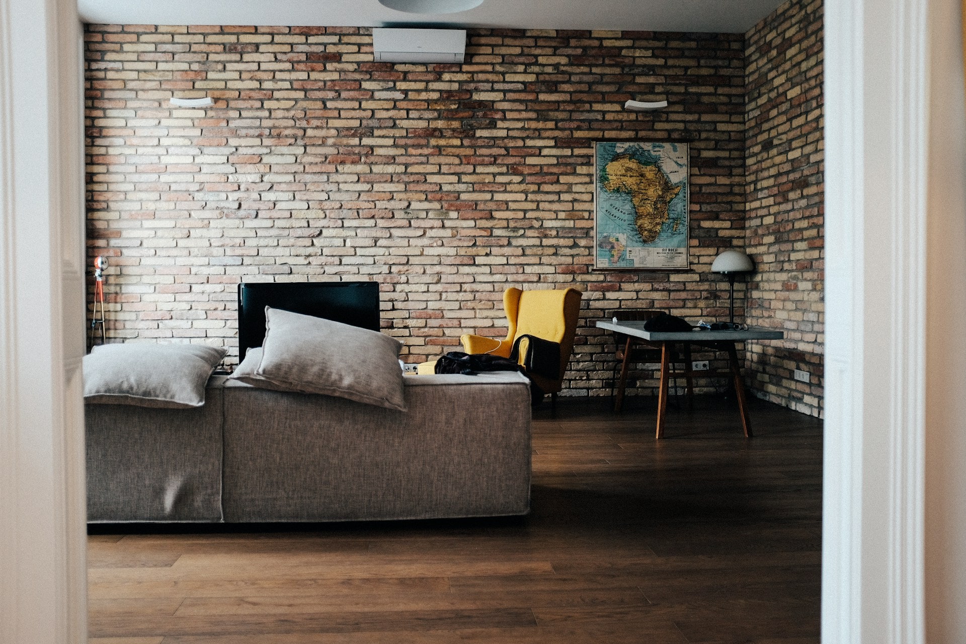 Basement remodeling in NJ featuring exposed brick, modern furnishings, and a multifunctional living space