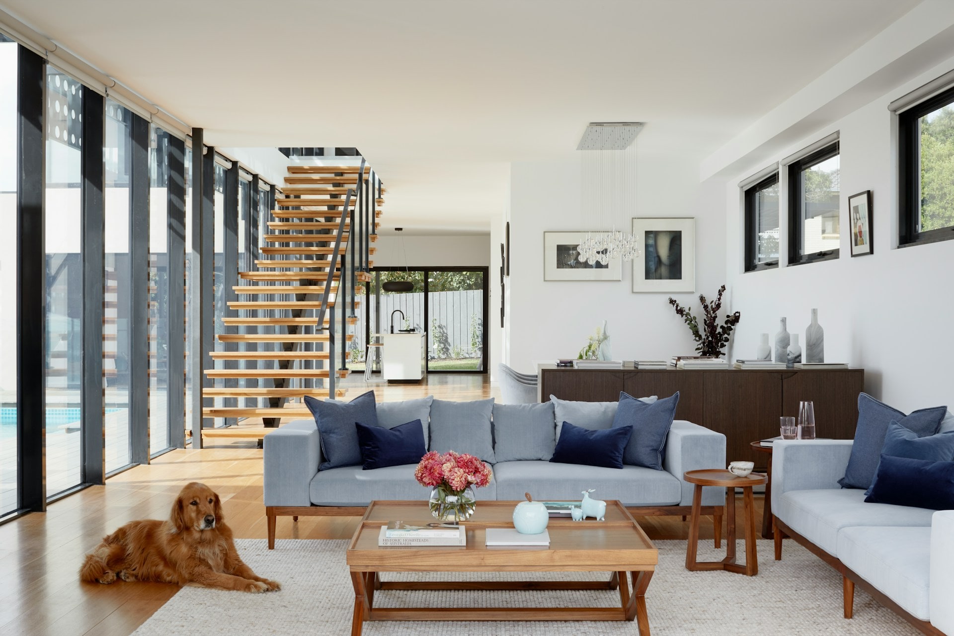 Modern open-concept living room with Scandinavian furniture, floating staircase, and natural light – Interior Renovation in New Jersey