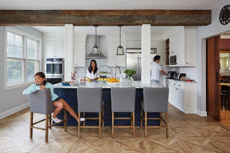 Modern family kitchen renovation in Jersey City townhouse with navy island, wood beams, and white cabinetry — designed by KraftMaster Renovations.