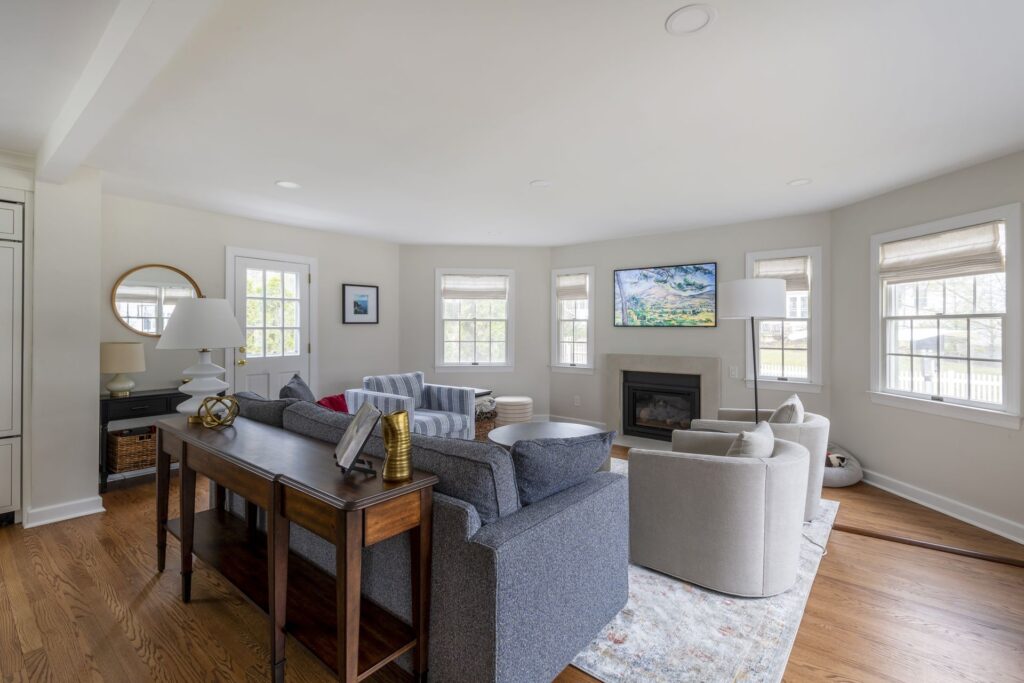 Home interior renovation by KraftMaster Renovations featuring a bright living room with neutral tones, fireplace, and large windows. Thoughtful design maximizes natural light, comfort, and the home’s overall potential.