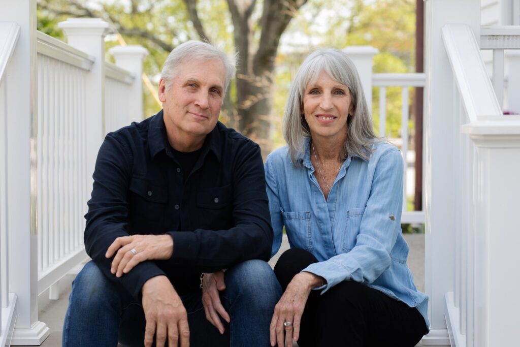 Owners of KraftMaster Renovations, a husband-and-wife team, sitting on their home’s front steps