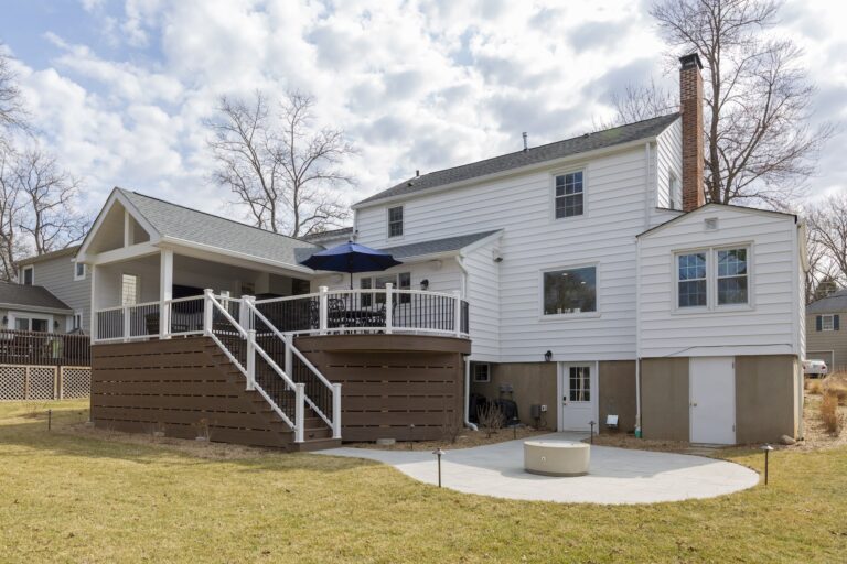 Renovated suburban home with elevated deck and backyard patio, reflecting smart home investment.