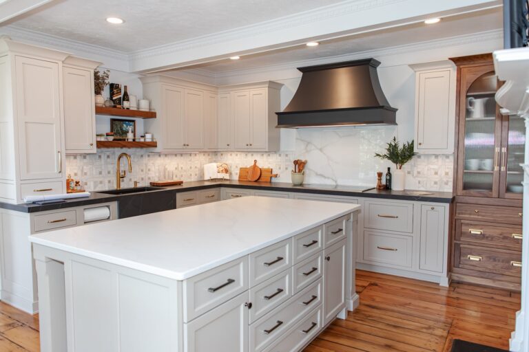 Elegant kitchen remodel with custom cabinets, brass hardware, and large center island by KraftMaster Renovations.