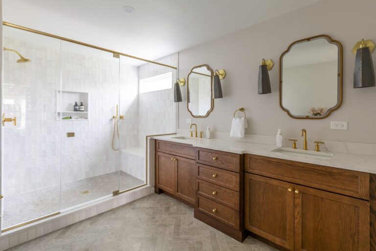 Luxury primary bathroom remodel with double vanity, walk-in shower, and gold fixtures – example of upscale renovation cost range.