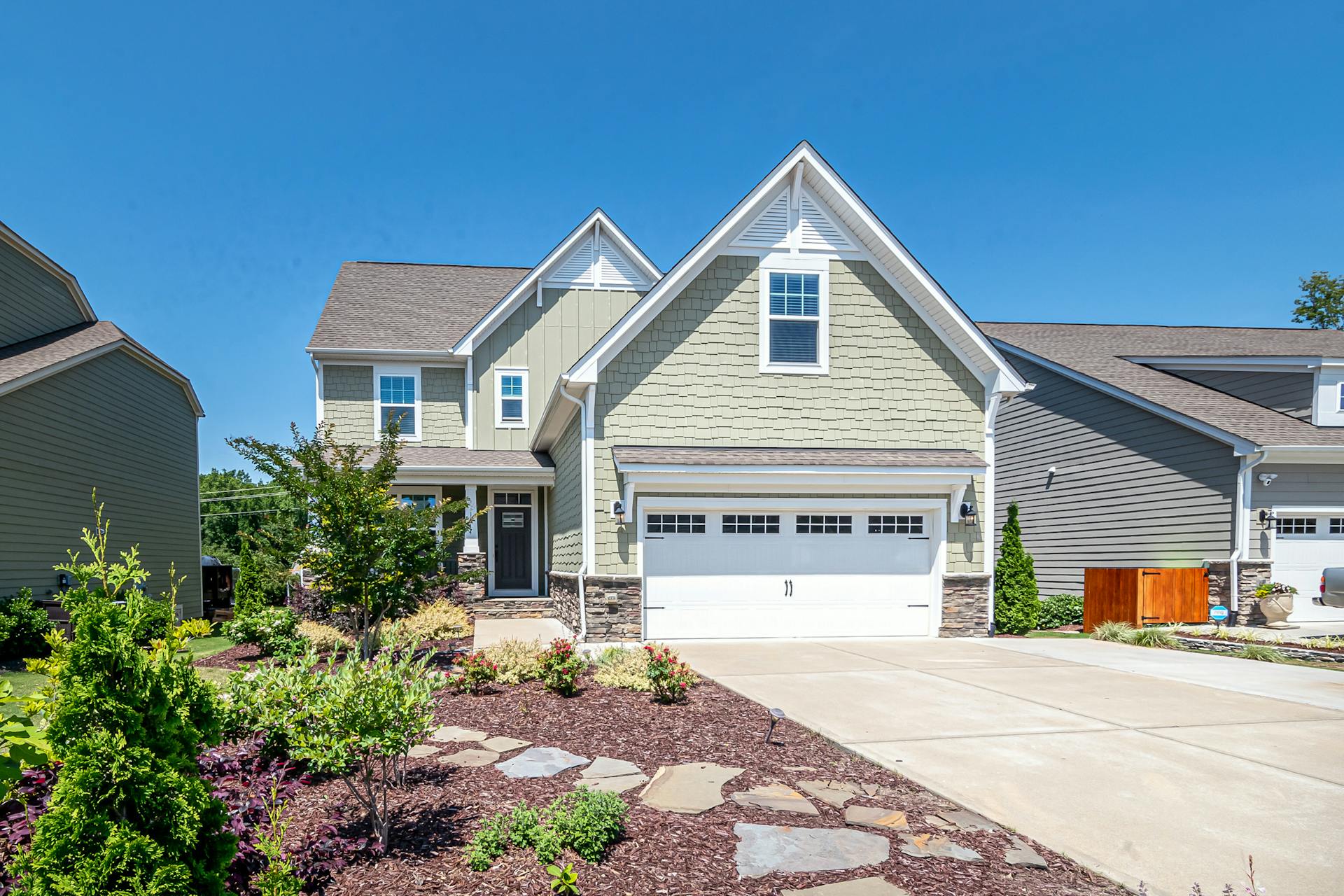 Front view of a well-maintained home addition with clean rooflines, siding, and landscaping