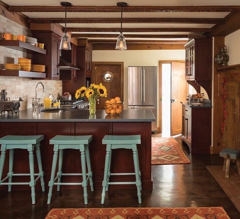Historic kitchen renovation in Chatham, NJ, with dark wood cabinetry, teal stools, exposed beams, and vintage-inspired finishes — designed by KraftMaster Renovations.