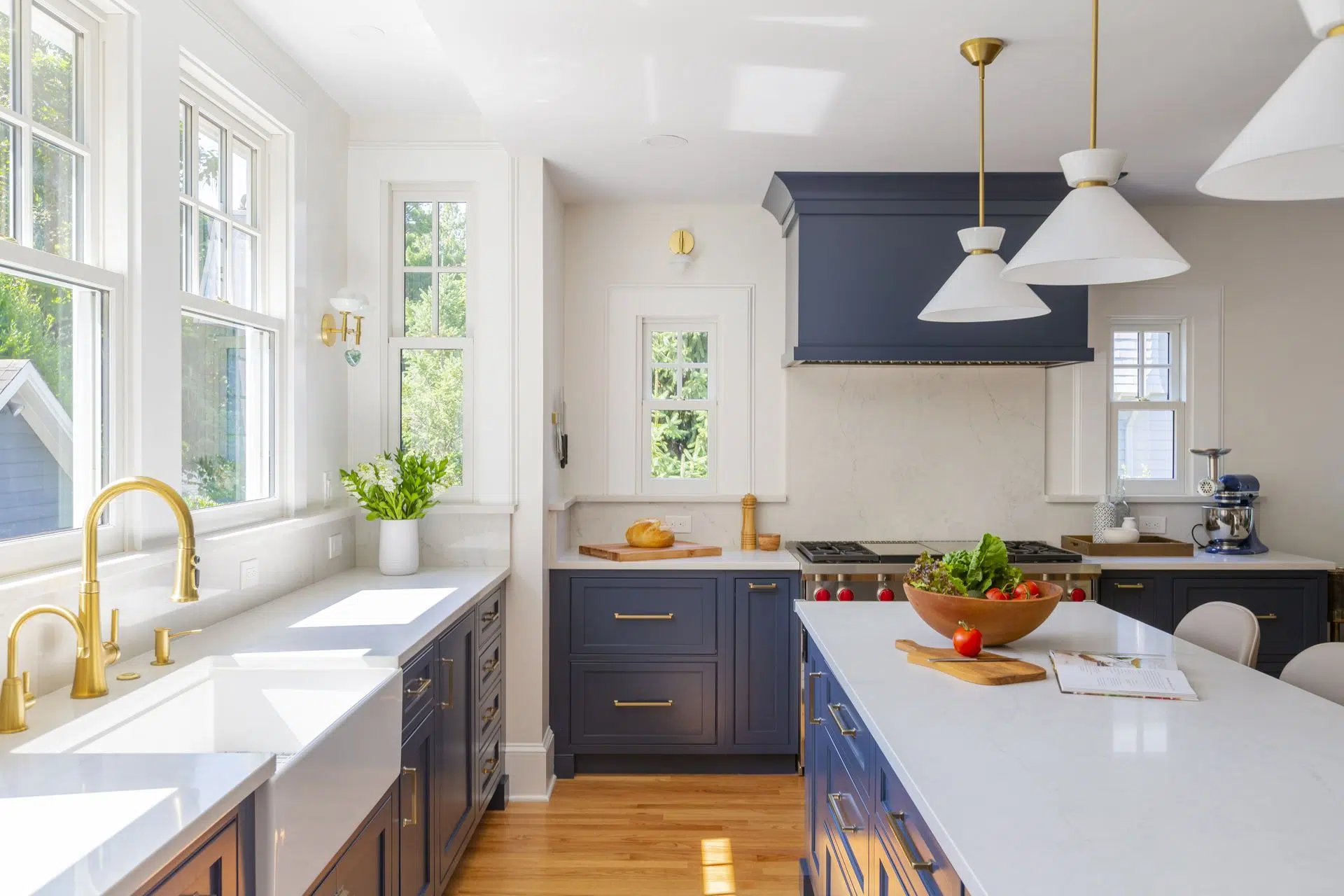 Stunning kitchen remodel with navy cabinets, brass fixtures, and natural light — Home Remodeling by KraftMaster Renovations.