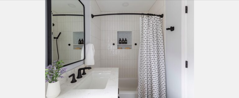 Compact bathroom remodel with white subway tile, black fixtures, niche storage, and shower curtain — designed by KraftMaster Renovations in Chatham, NJ