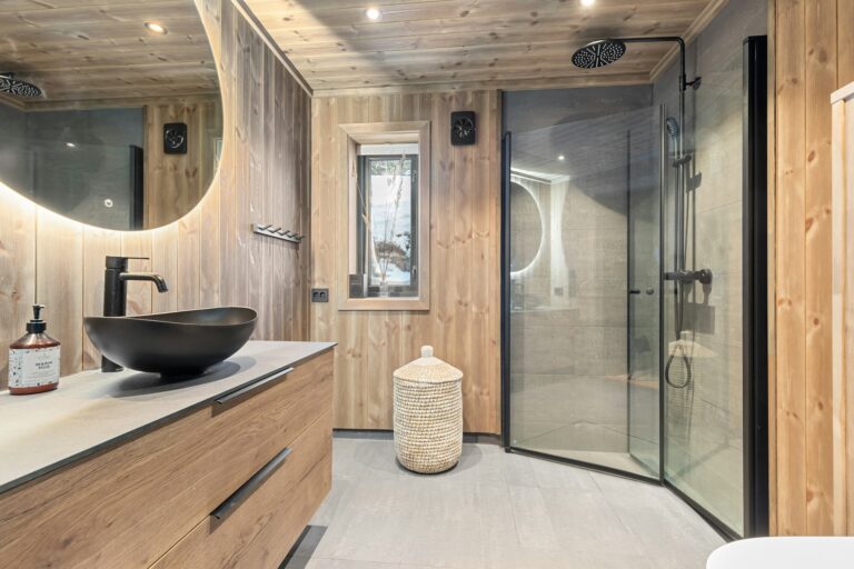 Modern home sauna bathroom with wood paneling and black fixtures