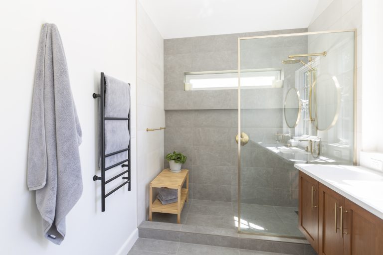 Award-winning master bathroom remodel by KraftMaster Renovations featuring a walk-in shower with glass enclosure, modern tile, and natural light.